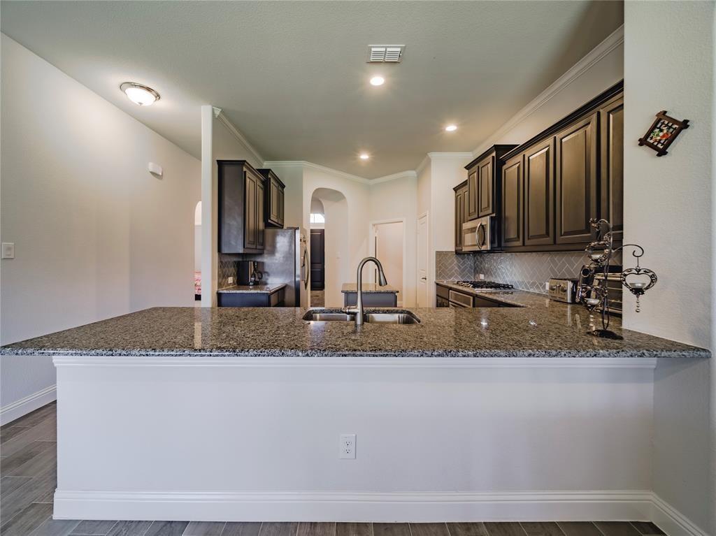 1809 Spinnaker Drive Denton, TX 76210 - Photo 7 of 18 a view of a kitchen with a sink and a granite counter top