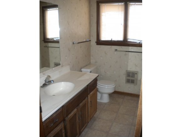 1222 Stetson Road, Unit 6 Prescott, AZ 86303 - Photo 4 of 6 a bathroom with a granite countertop toilet a sink and a mirror