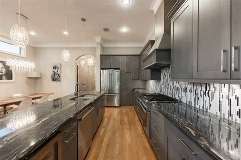 a kitchen with stainless steel appliances granite countertop a sink and a stove