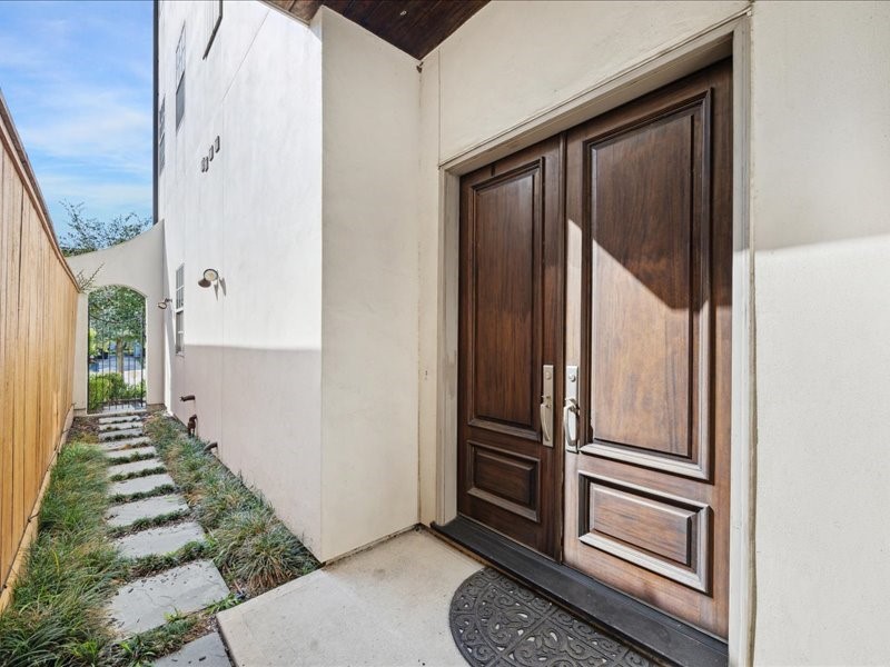 1944 Portsmouth Street Houston, TX 77098 - Photo 2 of 36 A private entrance lies just beyond the gated pedestrian entry, highlighted by striking double Magnolia wood doors that set the tone for the home’s refined design and craftsmanship.