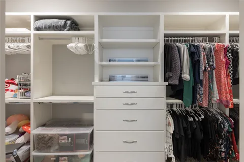 a view of walk in closet with clothes and shoes