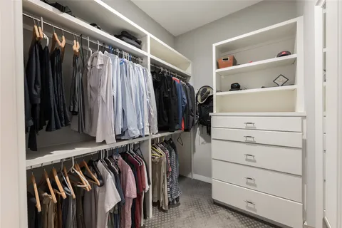 a view of walk in closet with clothes and shoes