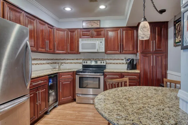 a kitchen with stainless steel appliances granite countertop wooden cabinets a stove top oven a sink and dishwasher a oven with wooden cabinets