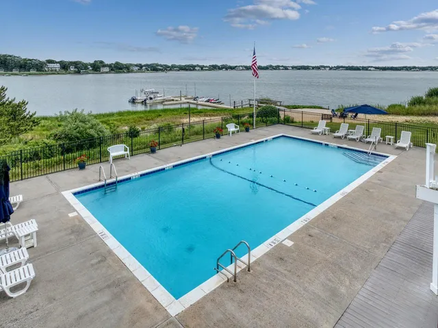 a view of a swimming pool with outdoor seating and lake view