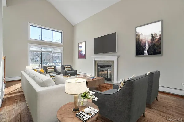 a living room with furniture a fireplace and a flat screen tv