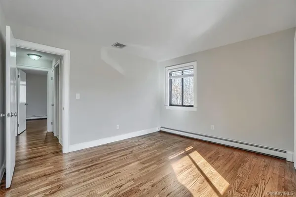a view of empty room with wooden floor