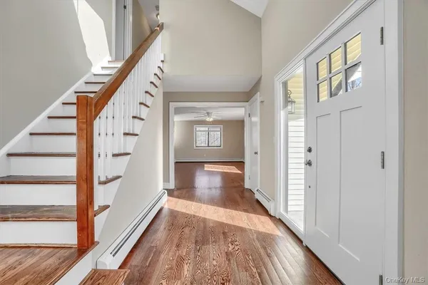 a view of an entryway with wooden floor and stairs