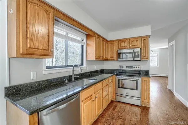 a kitchen with granite countertop a sink stove and cabinets