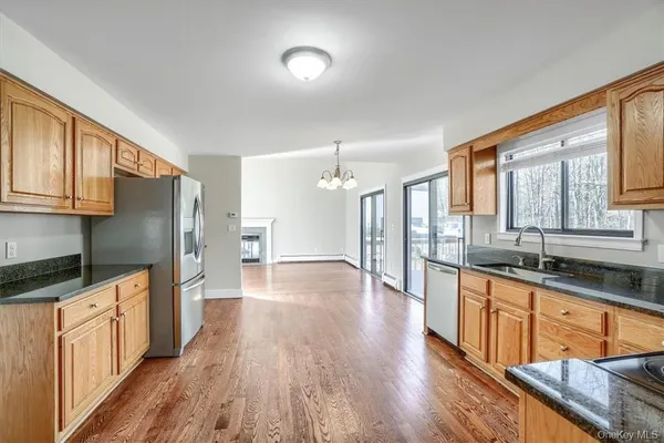 a large kitchen with granite countertop a large counter top space a sink stainless steel appliances and cabinets