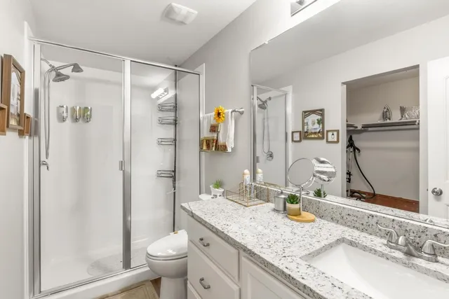a bathroom with a granite countertop sink toilet and shower