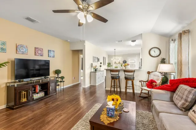 a living room with furniture and a flat screen tv with wooden floor