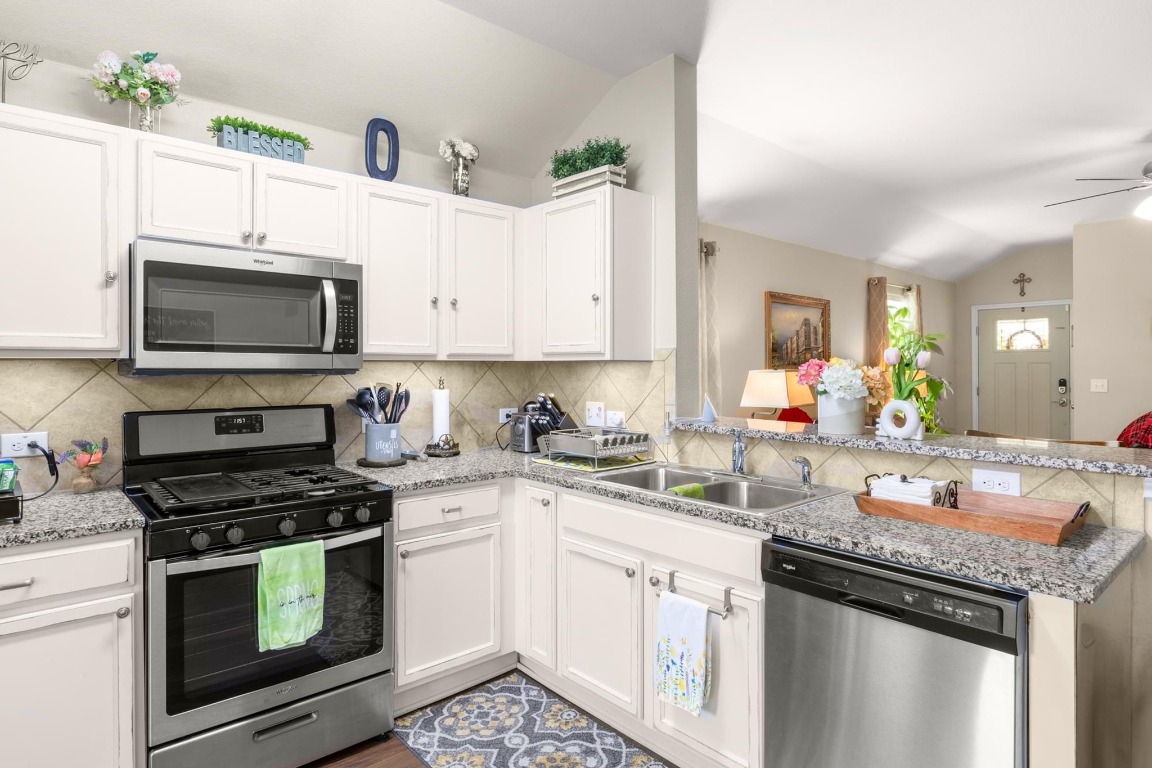 172 Alpha Kyle, TX 78640 - Photo 10 of 21 a kitchen with granite countertop a stove top oven microwave and cabinets