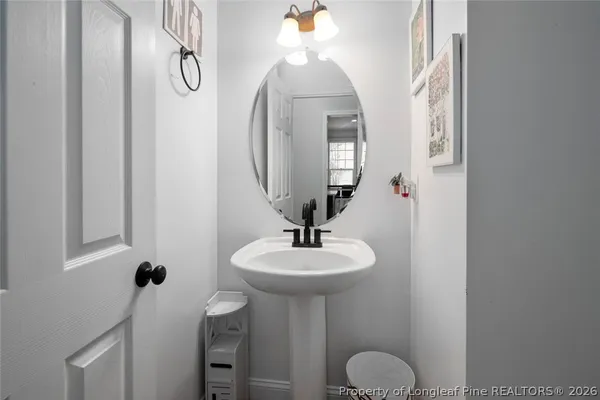 a bathroom with a sink a light fixture and a mirror