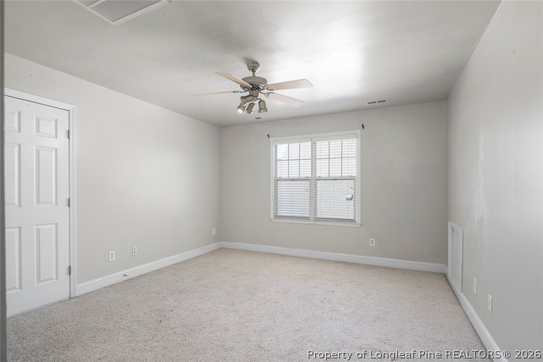 98 Cottswold Lane Spring Lake, NC 28390 - Photo 25 of 30 an empty room with chandelier fan and windows