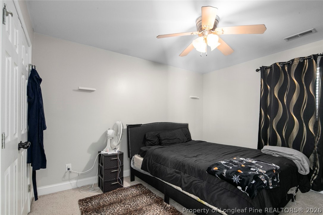 98 Cottswold Lane Spring Lake, NC 28390 - Photo 27 of 30 a bedroom with a bed and a chandelier