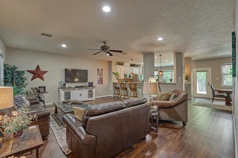 a living room with furniture and a wooden floor