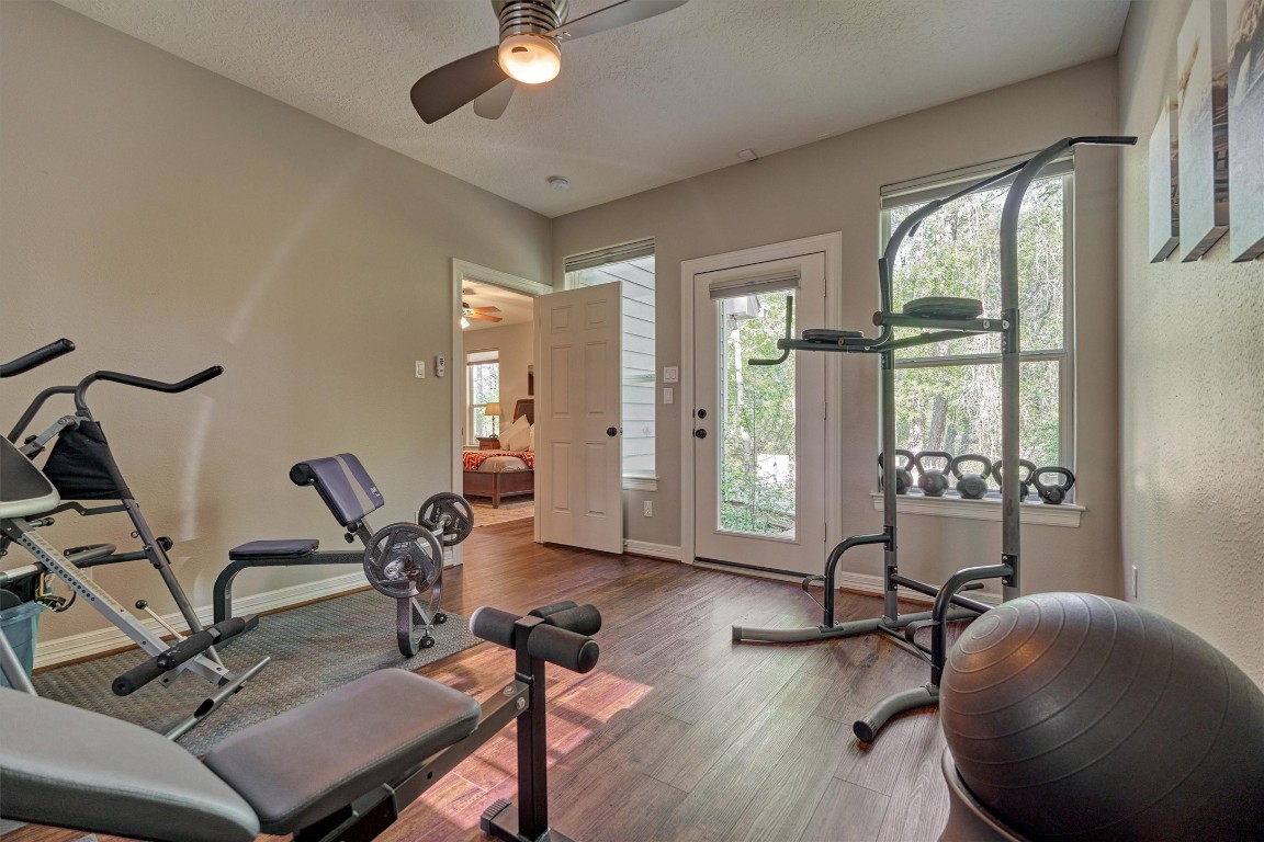 28694 West Fm 1097 Road Montgomery, TX 77356 - Photo 33 of 50 This room is located just off of the primary suite and provides access to the back deck. While currently being used as a weight room, it would also make a great second study or sunroom!