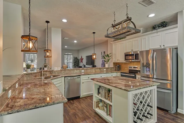 a kitchen with stainless steel appliances granite countertop a sink stove and refrigerator