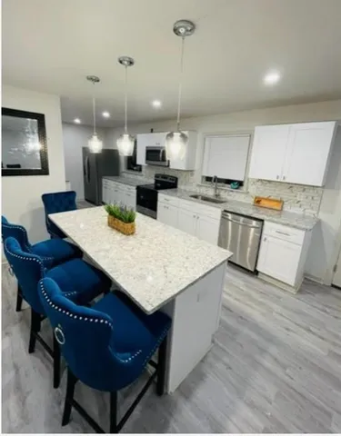 a kitchen with a table chairs sink and cabinets