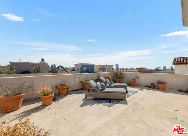 a view of a terrace with couches and sky view