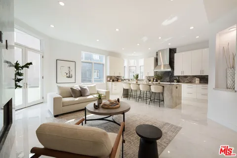 a living room with furniture and a view of kitchen
