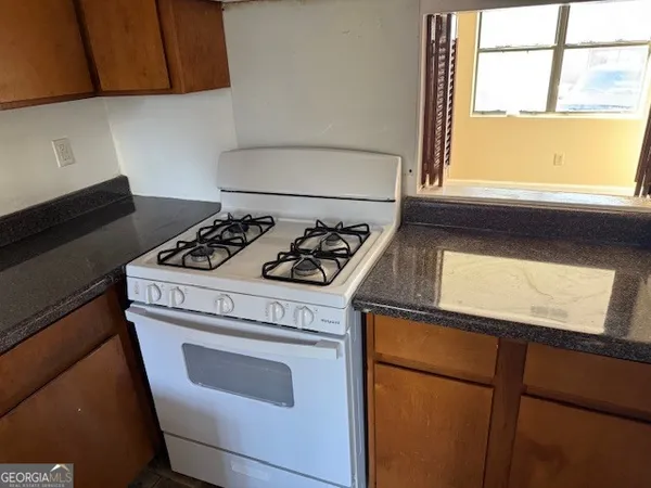 a kitchen with a stove cabinets and a window