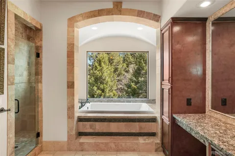 a bathroom with a granite countertop tub shower and sink