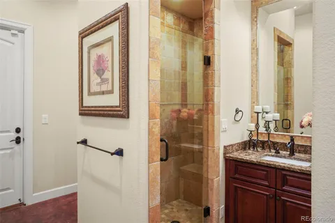 a bathroom with a granite countertop shower sink and mirror