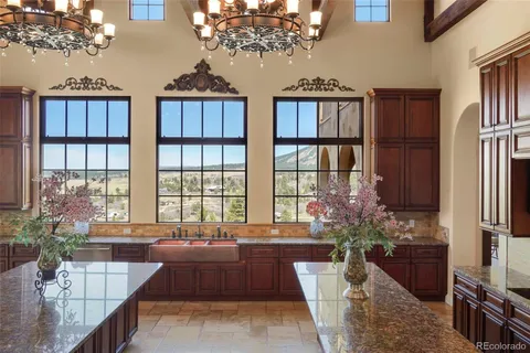 a large kitchen with granite countertop a stove a sink and dishwasher
