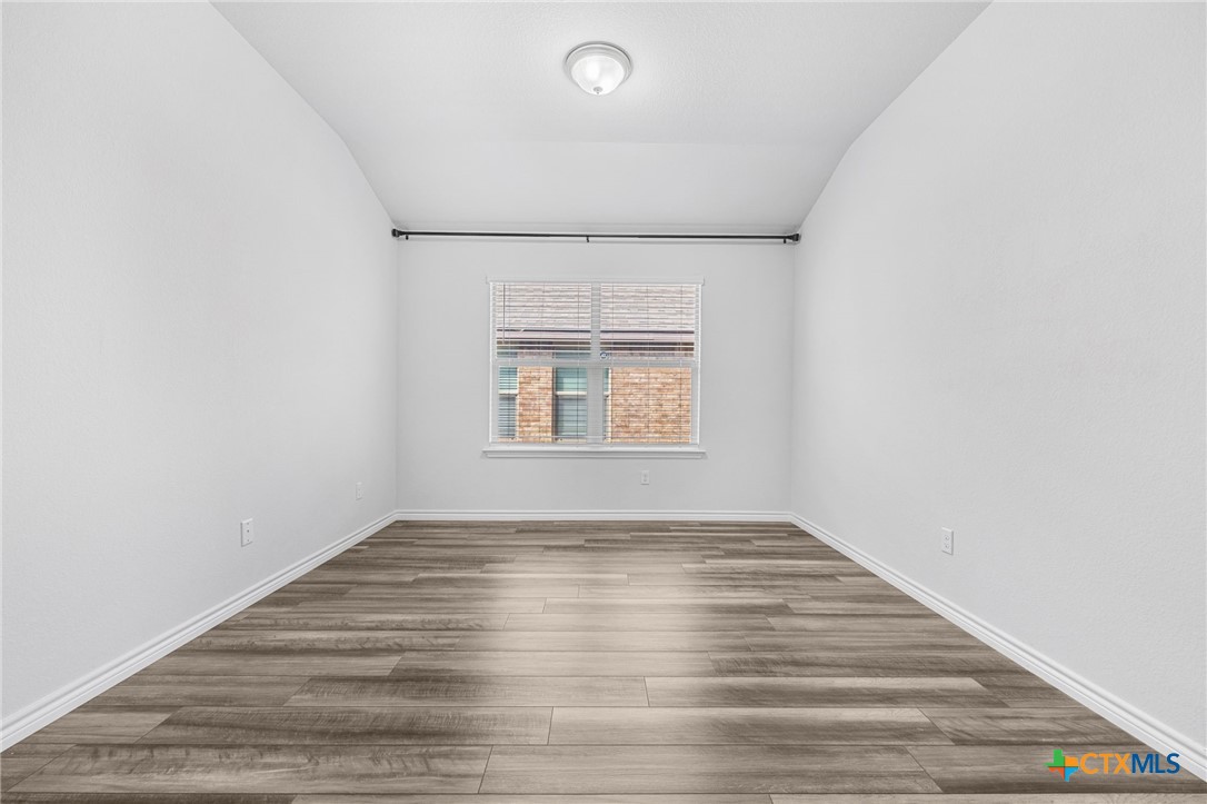 6166 Lavaca Drive Belton, TX 76513 - Photo 8 of 41 an empty room with wooden floor cabinet and windows