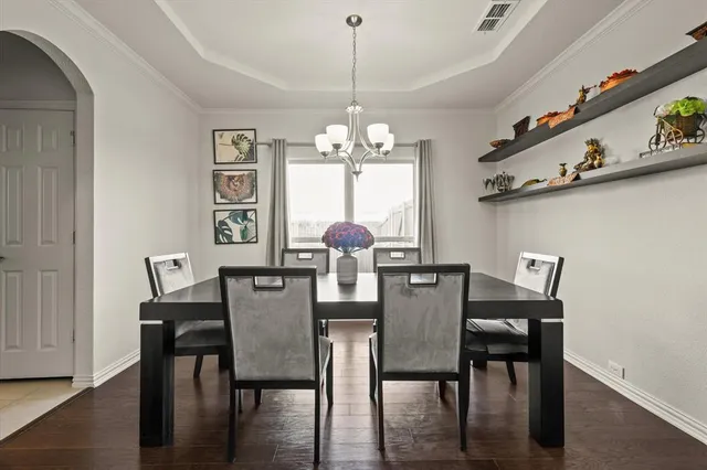 a dining room with furniture a chandelier and wooden floor