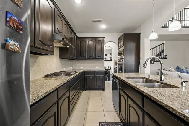 a kitchen with granite countertop stainless steel appliances and wooden cabinets