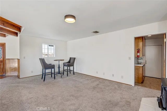 a room with furniture a flat screen tv and kitchen view