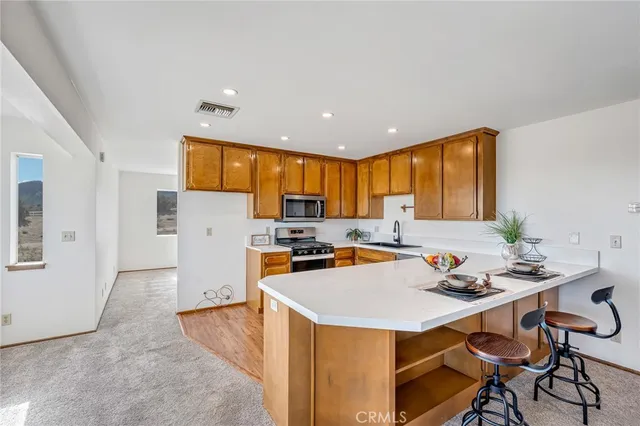 a kitchen with stainless steel appliances granite countertop a sink a stove and a refrigerator