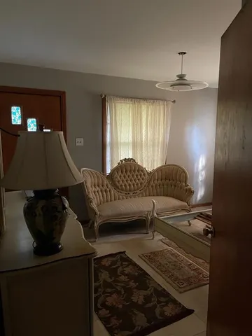 a living room with furniture and a chandelier