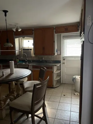 a kitchen with a table chairs sink and cabinets