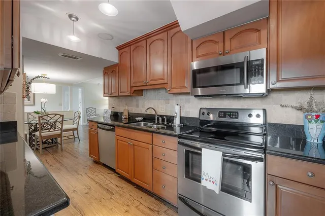 a kitchen with stainless steel appliances granite countertop a stove a microwave and cabinets