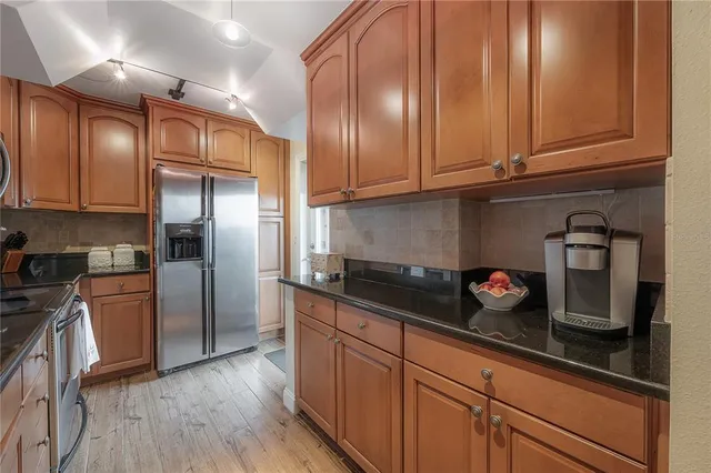 a kitchen with metallic refrigerator freezer and a granite counter tops