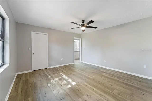 a view of room with wooden floor and ceiling fan