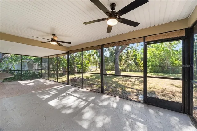 a view of an empty room with a floor to ceiling window and a ceiling fan