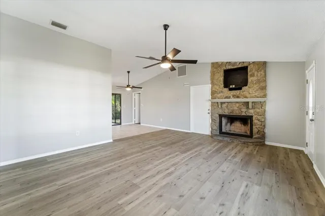 a view of empty room with wooden floor fireplace and windows