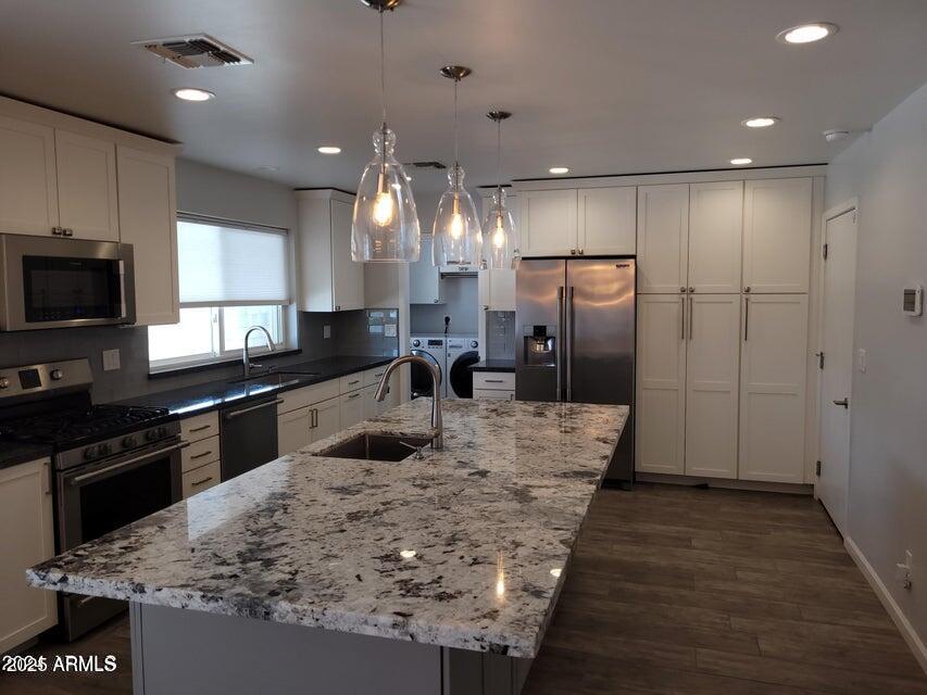 a large kitchen with kitchen island a sink stainless steel appliances and cabinets