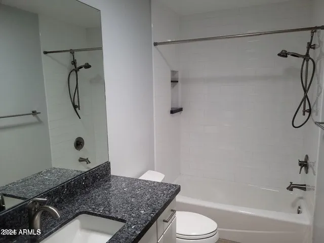 a bathroom with a granite countertop sink toilet and shower