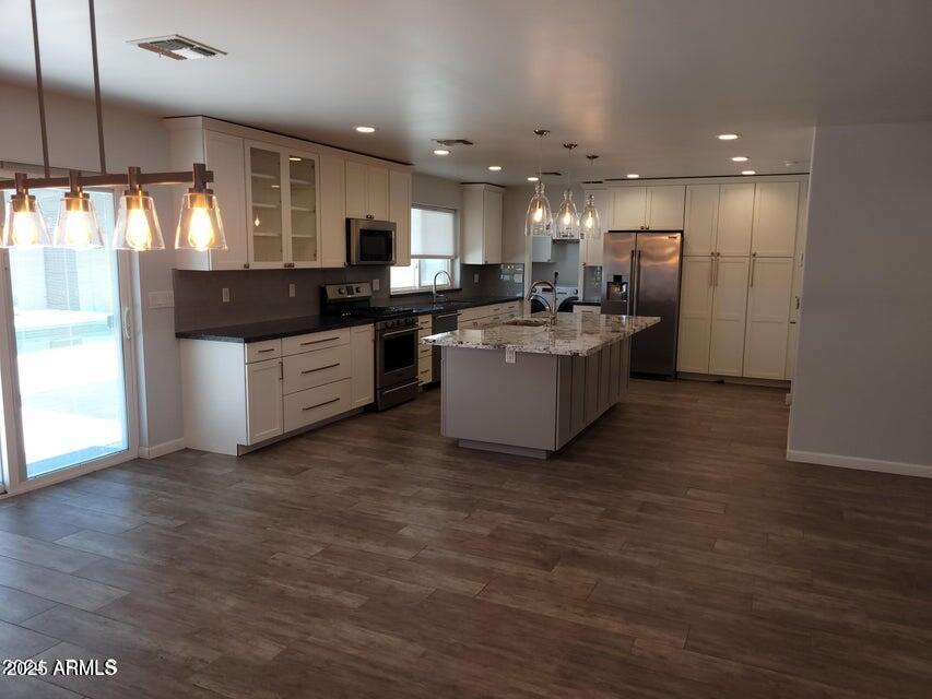 2821 East Cortez Street Phoenix, AZ 85028 - Photo 3 of 18 a kitchen with stainless steel appliances kitchen island granite countertop a refrigerator a sink a stove and a wooden floors