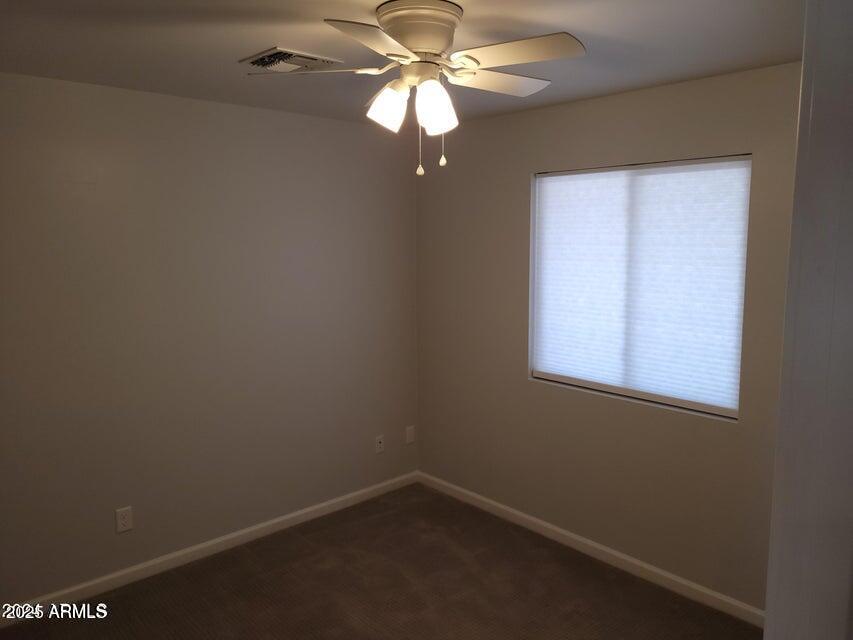2821 East Cortez Street Phoenix, AZ 85028 - Photo 7 of 18 an empty room with windows and fan