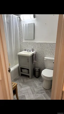 a bathroom with a toilet a sink and a mirror