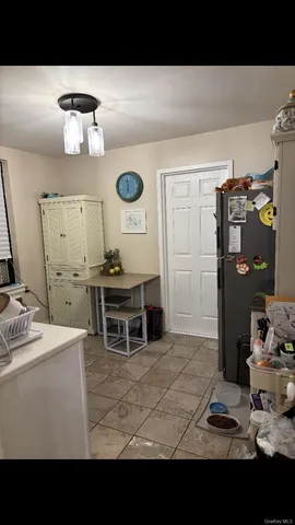 a living room with stainless steel appliances kitchen island granite countertop a sink and a refrigerator