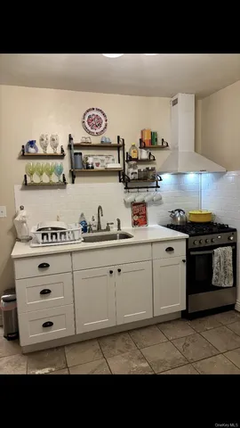 a kitchen with kitchen island white cabinets and black appliances