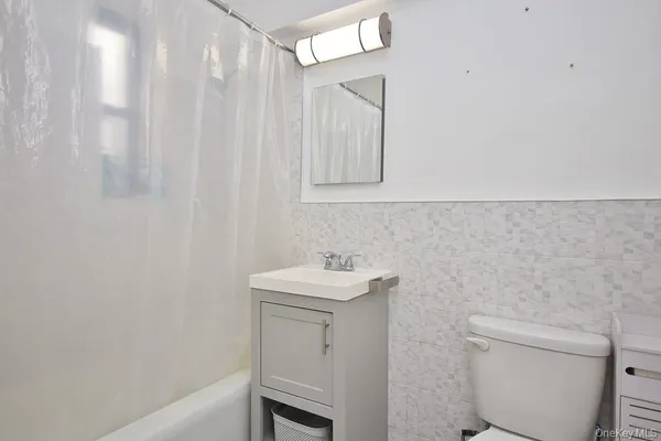 a bathroom with a sink toilet and a mirror