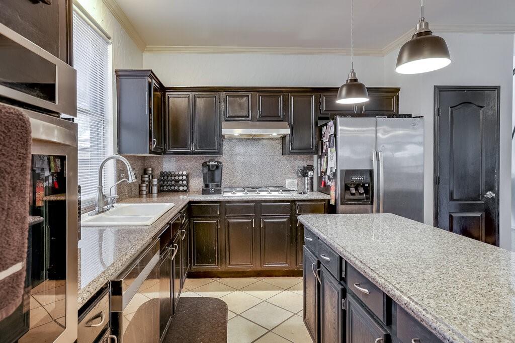 706 Gentry Drive Arlington, TX 76018 - Photo 14 of 39 a kitchen with stainless steel appliances granite countertop a sink stove and refrigerator